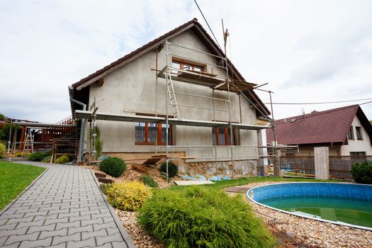 repaired rural house, fixed facade, insulation and painted to green  color witg swimming pool