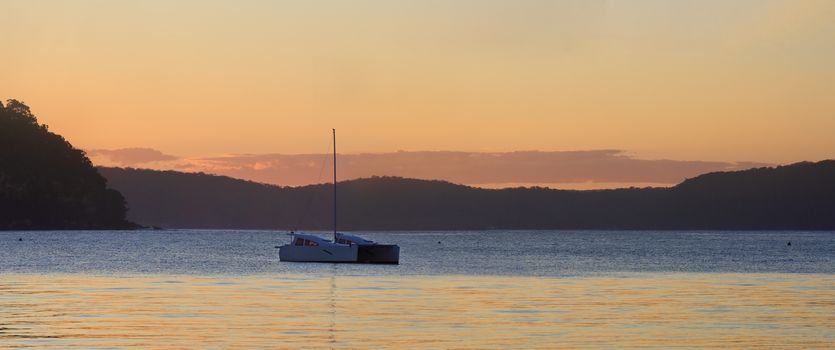Simple and serenel sunset on the last day of winter at beautiful travel destination Palm Beach, Sydney - a sign of the warm days ahead.  Catamaran on the water and views to West Head  Patonga and Hawkesbury, from Pittwater side.