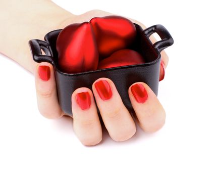 Women Hand with Red Manicure Hold Black Container with Red Plastic Hearts isolated on white background