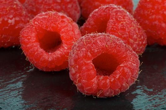 Frame of Fresh Sweet Raspberries with Water Drops on Black Wet background closeup