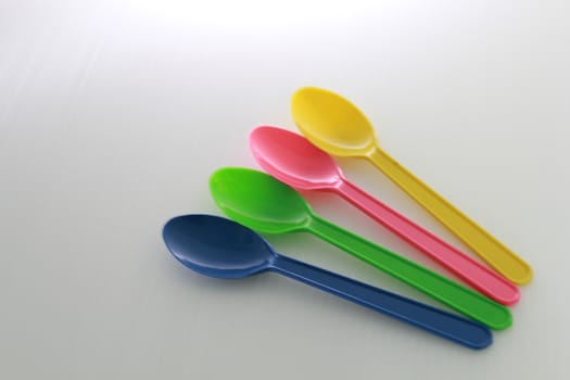 There are colour plastic spoons use for eating icecream and desert.