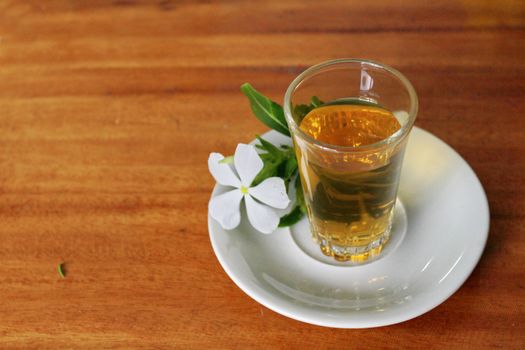 The glass of green tea mix flower tea.Decoration in serve with vinca.