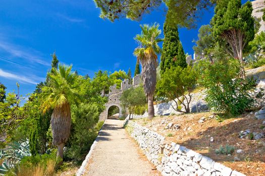 Historic Hvar fortification wall in nature with palm, agave - Dalmatia, Croatia