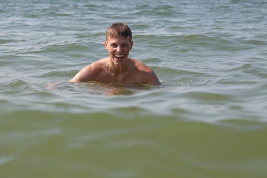 A man swimming in the ocean and smiling