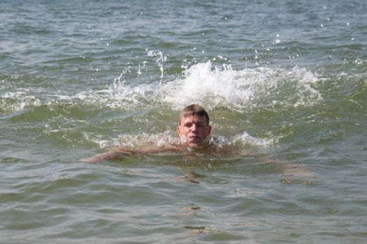 A teen male swimming in the ocean