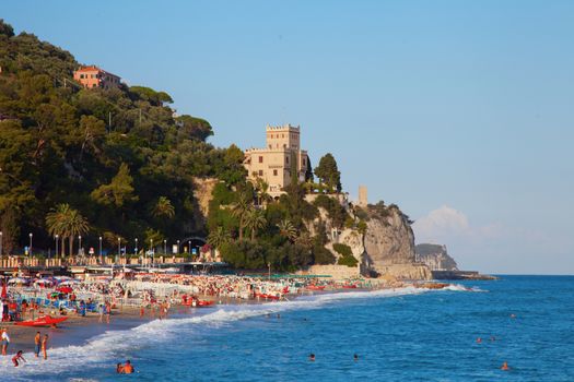 Beach and sea of Finale Ligure, Italy, with castle on the hill