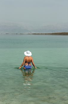 Woman in the water of the Dead sea Israel