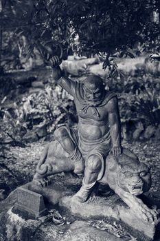 Old ruined Arhat Kanakbharadvaja statue in forest, Taiwan, Asia.