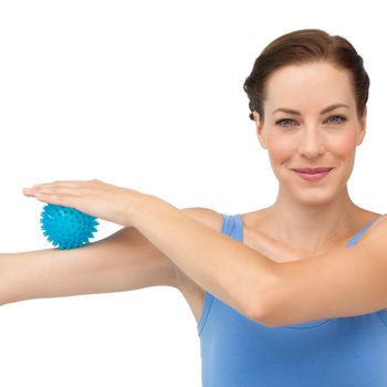 Portrait of a content young woman holding stress ball on arm over white  background