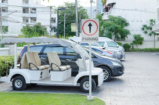 Cars on a parking lot and parking sign.