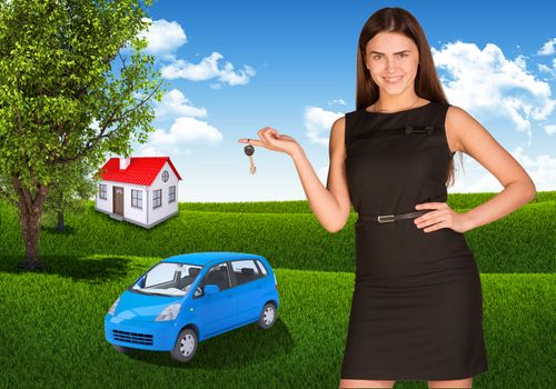 Beautiful young woman with key in hand. Small automobile and house on grass as backdrop