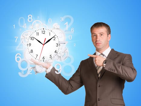 Businessman hold clock with flying figures. Time concept
