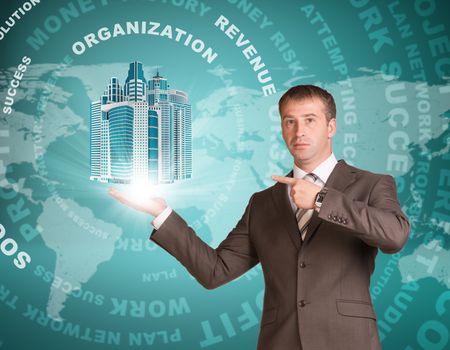 Business man hold skyscrapers in hand. Business words and world map as backdrop