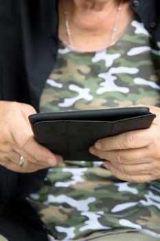 Senior women relaxing at home reading E-book on her tablet.