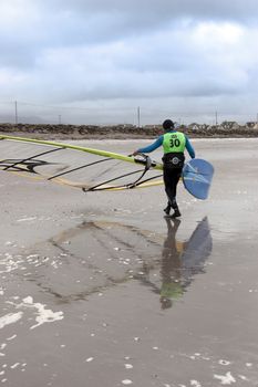 windsurfer finishing up after race and surf on the beach in the maharees county kerry ireland