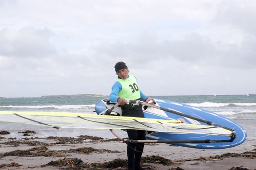 windsurfer getting equipment ready on the beach in the maharees county kerry ireland