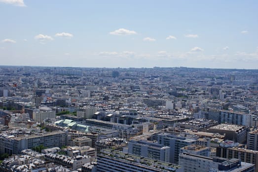 Photo is showing various views onto Paris, France with its many houses and roofs.