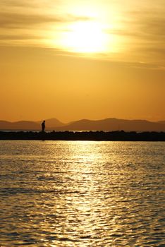 Photo is showing sunset above the beach and sea of Mallorca, Spain.