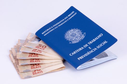 Brazilian work document and social security document (carteira de trabalho) and brazilian currency (Real) on white background