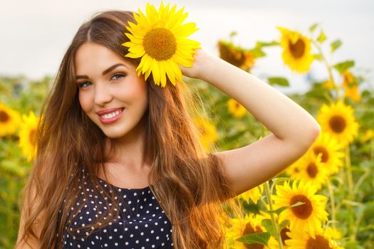 Cute girl in the field full of sunflowers