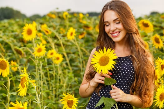 Cute girl in the field full of sunflowers