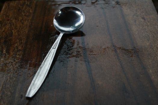 The ball spoon is on the wet table after raining.