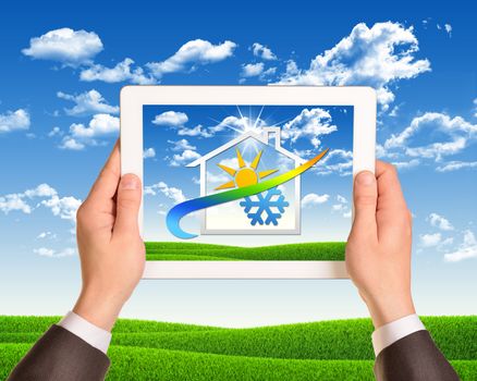 Man hands hold tablet pc with weather icon. Nature landscape as backdrop. Business concept