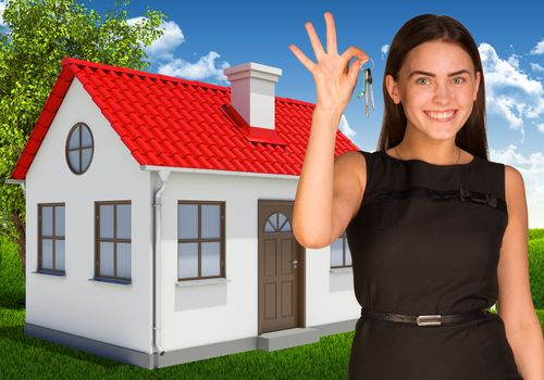 Beautiful woman holding keys. House, green field and forest on background