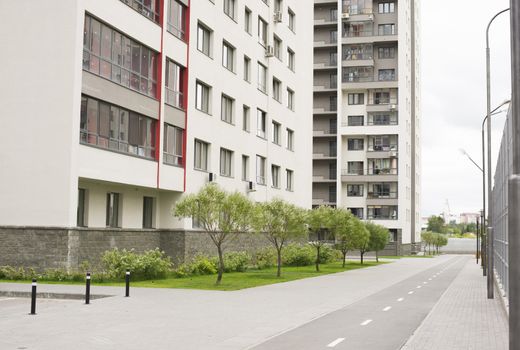 Modern building with road, grass and trees. Urban background