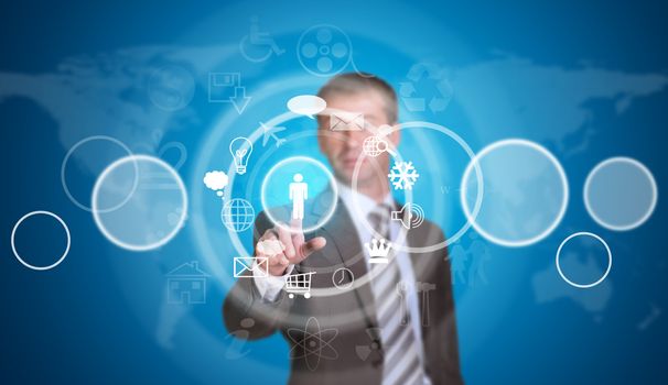 Businessman in suit pointing her finger at cloud icons. World map as backdrop