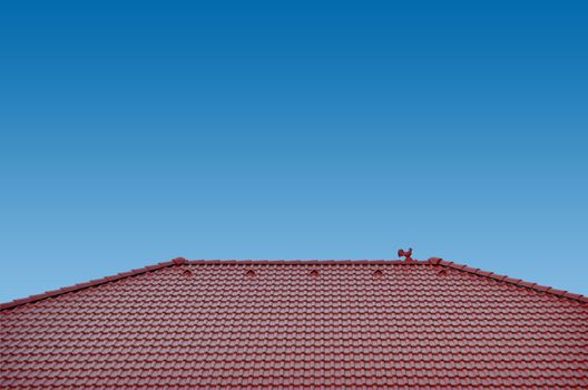 roof with brown tiles on a background of blue sky, new roof