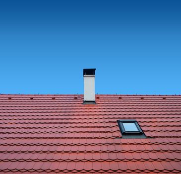 roof with brown tiles on a background of blue sky, new roof