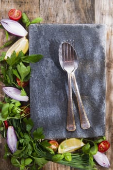 Presentation of a flat stone with vegetables