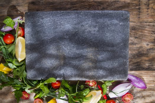 Presentation of a flat stone with vegetables