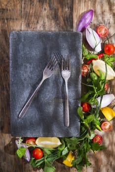 Presentation of a flat stone with vegetables