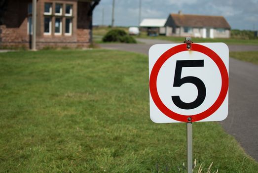 A five miles per hour sign on a grass verge