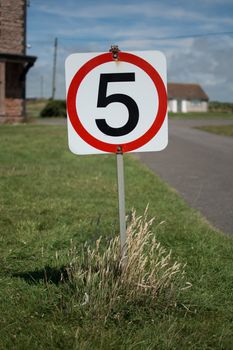 A five miles per hour sign on a grass verge