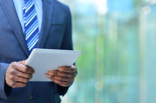Midsection of businessman holding digital tablet at outdoors