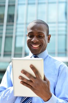 Handsome man using his tablet computer at outdoors