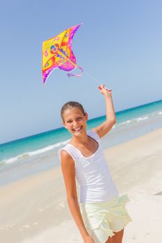Summer vacation - Cute girl flying kite beach outdoor.