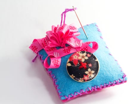 Photo presents various sewing accessories, including buttons, needles and bows.