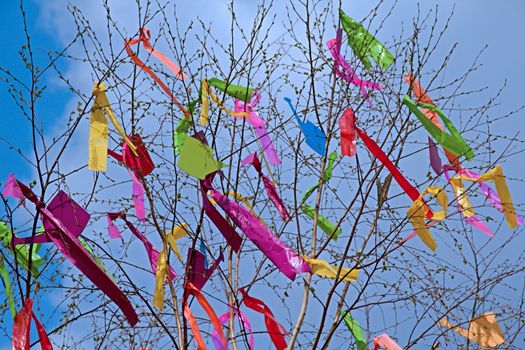 Photo shows colourful maypole in front of the blue sky.