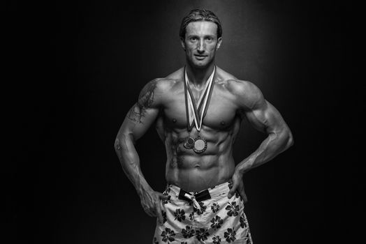 Male Fitness Competitor Showing His Winning Medal