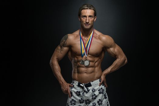 Male Fitness Competitor Showing His Winning Medal