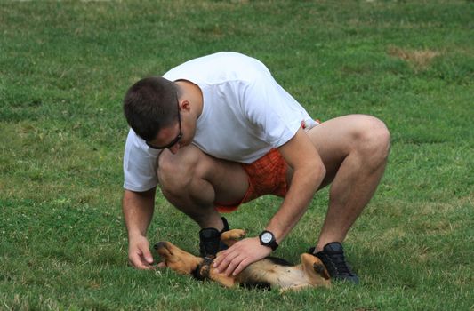 Young man cuddles sweet mongrel dog
