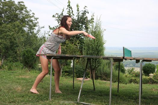 Young woman  playing table tennis in nature