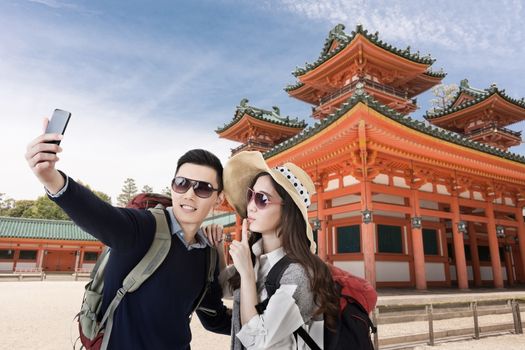 Asian couple travel and selfie in Heian Jingu Shrine, Kyoto, Japan.