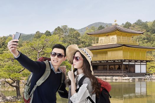 Asian couple travel and selfie in The Golden Pavilion ,Kyoto, Japan.