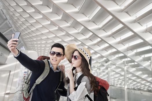 Asian couple travel and selfie in the Taipei Taoyuan International airpor, Taiwan.