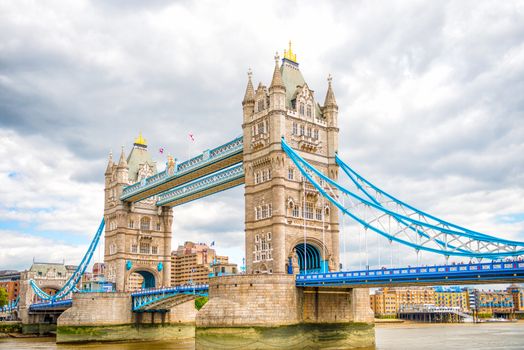 London Tower Bridge is a combined bascule and suspension bridge in London which crosses the River Thames. It is close to the Tower of London, from which it takes its name, and has become an iconic symbol of London.

Built during 1886 – 1894, the bridge consists of two towers tied together at the upper level by means of two horizontal walkways, designed to withstand the horizontal forces exerted by the suspended sections of the bridge on the landward sides of the towers. The vertical component of the forces in the suspended sections and the vertical reactions of the two walkways are carried by the two robust towers. 

The bascule pivots and operating machinery are housed in the base of each tower. The bridge's present colour scheme dates from 1977, when it was painted red, white and blue for Queen Elizabeth II's silver jubilee. Originally it was painted a mid-greenish-blue colour.

Photographed using Nikon D800E (36 megapixels) DSLR with AF-S NIKKOR 24-70 mm f/2.8G ED lens at focal length 34 mm, ISO 100. It is a High Dynamic Range (HDR) photograph.